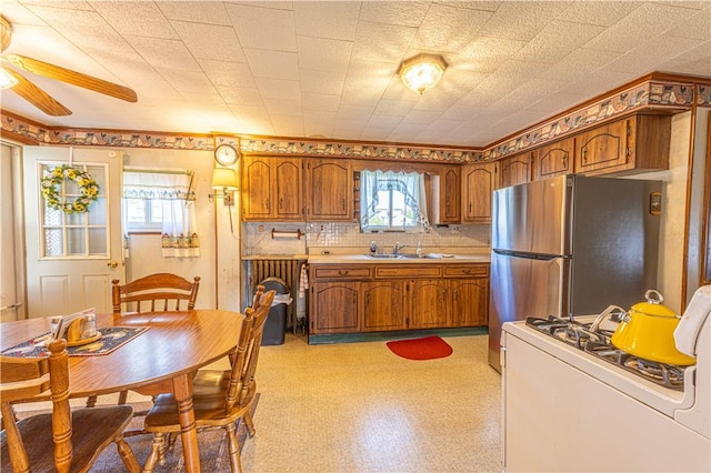 14 Cedar St, Masontown, PA 15461 - kitchen featuring ceiling fan, brown cabinetry, white range with gas stovetop, and freestanding refrigerator