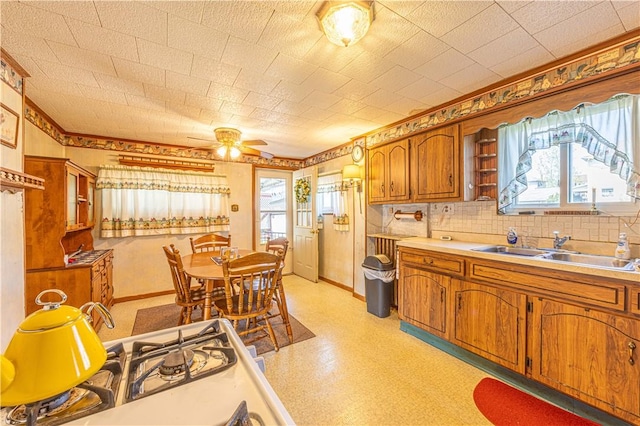 14 Cedar St, Masontown, PA 15461 - kitchen with a ceiling fan, baseboards, light countertops, brown cabinets, and a sink