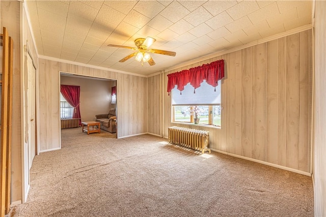 14 Cedar St, Masontown, PA 15461 - carpeted empty room featuring ornamental molding, radiator, ceiling fan, and wood walls