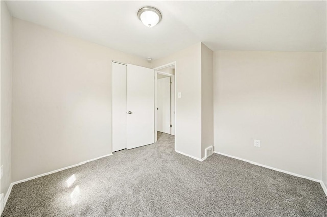 unfurnished bedroom featuring baseboards, carpet, a closet, and visible vents