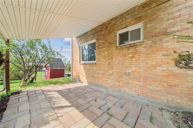 view of patio with an outbuilding and a shed