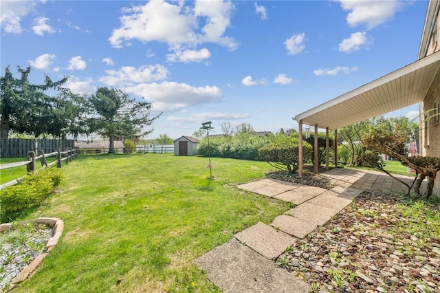 view of yard with a storage shed, fence, and an outdoor structure