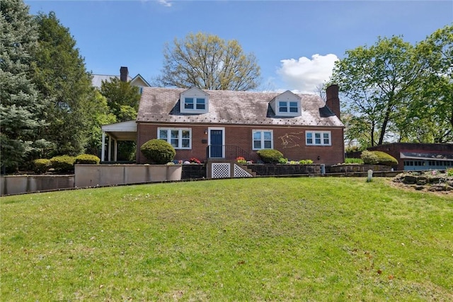cape cod house featuring brick siding, fence, a front yard, and a chimney