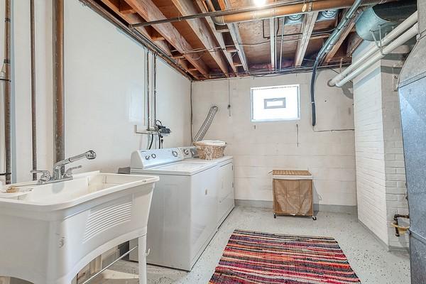 washroom with a sink, laundry area, and washing machine and clothes dryer