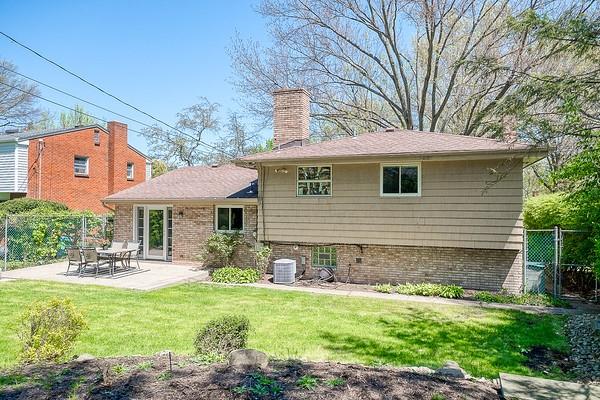 rear view of house featuring fence, a patio area, and brick siding