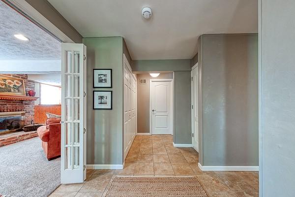 hall featuring baseboards and light tile patterned floors
