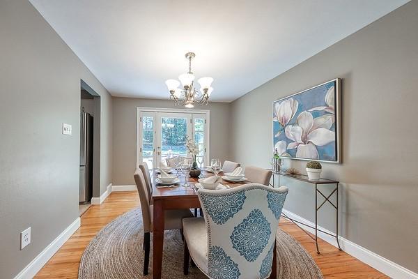 dining room featuring an inviting chandelier, baseboards, and light wood-style floors