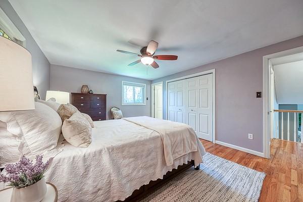 bedroom featuring baseboards, ceiling fan, wood finished floors, and a closet