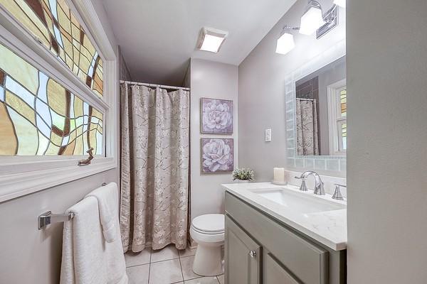 full bathroom featuring tile patterned flooring, a wealth of natural light, toilet, and vanity