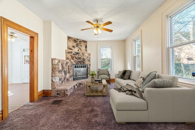 carpeted living room featuring a fireplace and a ceiling fan