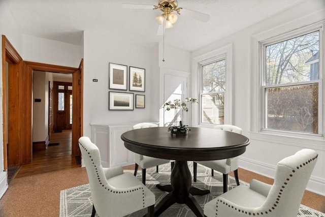 dining room featuring a healthy amount of sunlight, baseboards, and light carpet