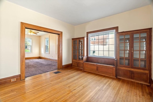 spare room featuring baseboards, visible vents, and light wood finished floors