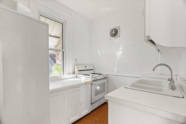 kitchen with visible vents, light countertops, white cabinetry, white range with electric stovetop, and a sink