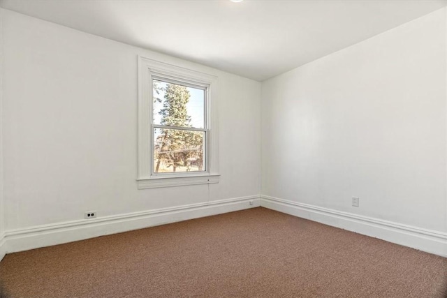 spare room with baseboards and carpet