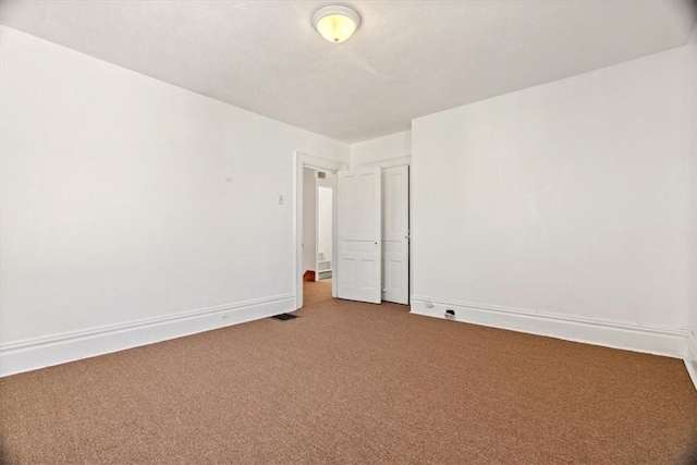 unfurnished room with baseboards and carpet flooring