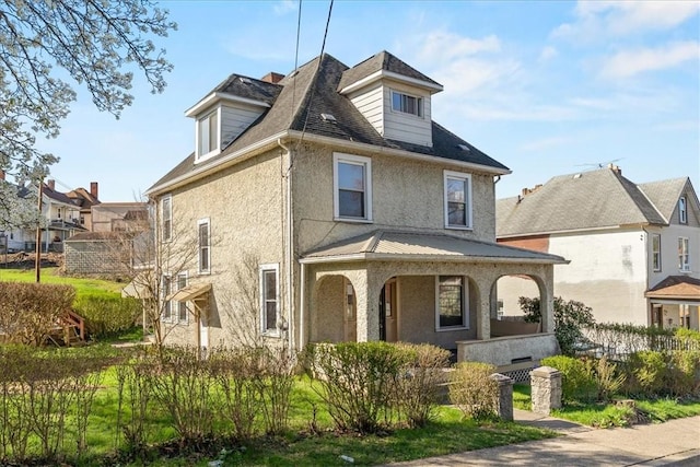 traditional style home featuring stucco siding and a porch