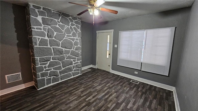 spare room with baseboards, a ceiling fan, wood finished floors, and visible vents