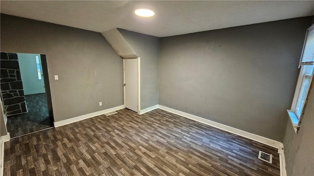 interior space with baseboards, visible vents, and dark wood-type flooring