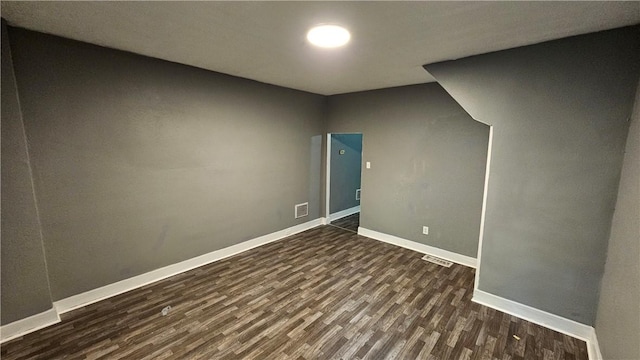 interior space featuring baseboards, dark wood-style floors, and visible vents
