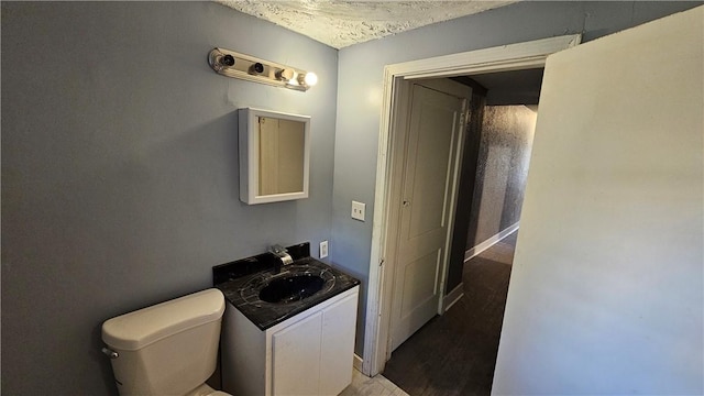 half bath featuring vanity and toilet