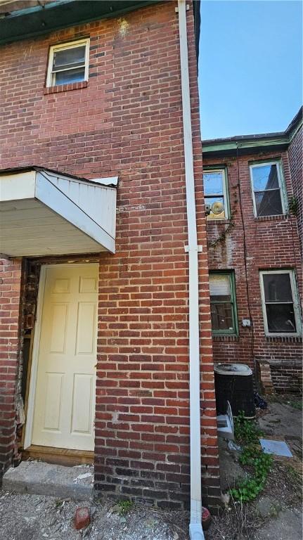 view of home's exterior with central AC and brick siding