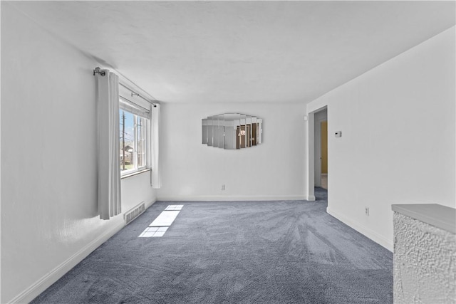 carpeted empty room featuring baseboards and visible vents