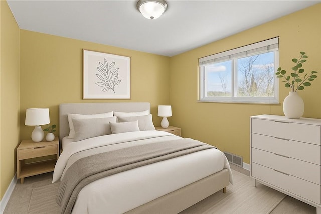bedroom featuring baseboards and visible vents