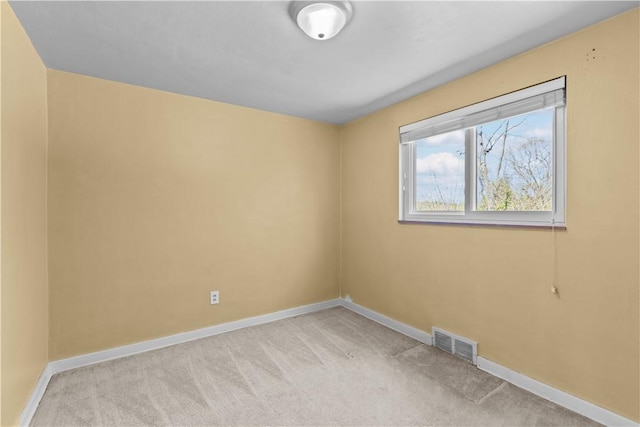 carpeted spare room with visible vents and baseboards