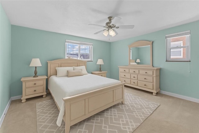 bedroom with light colored carpet, baseboards, and multiple windows