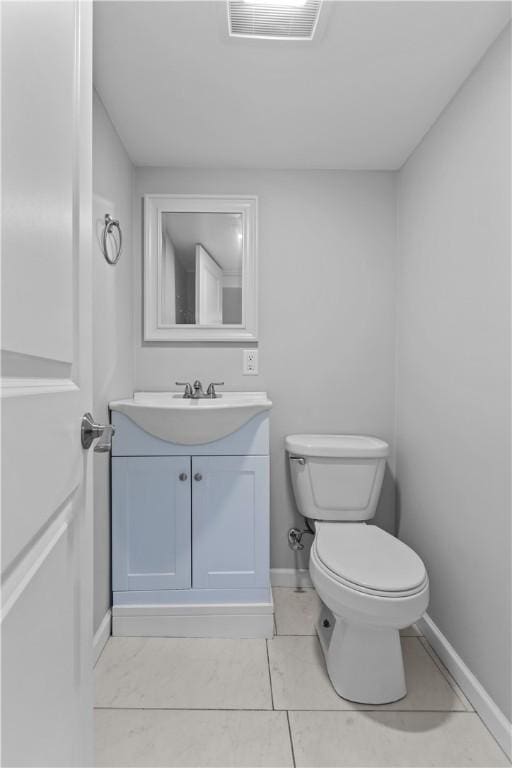 half bath with visible vents, baseboards, toilet, and vanity