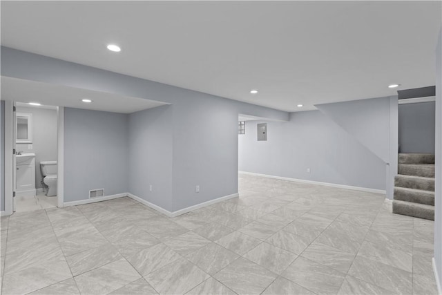 finished basement featuring visible vents, recessed lighting, stairs, and baseboards