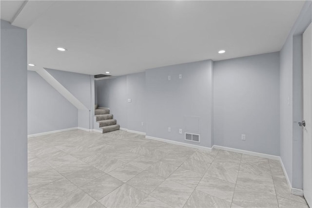 finished below grade area featuring baseboards, recessed lighting, stairs, and visible vents
