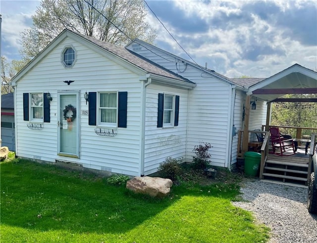 view of front of property with a wooden deck, a shingled roof, and a front lawn