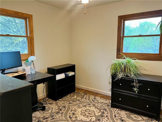 office with baseboards, a ceiling fan, wood finished floors, and visible vents