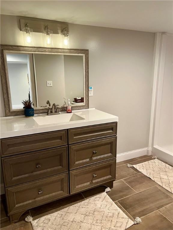bathroom featuring vanity, baseboards, and tile patterned flooring
