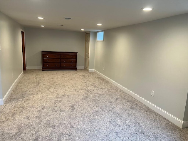 finished below grade area featuring recessed lighting, baseboards, visible vents, and light carpet