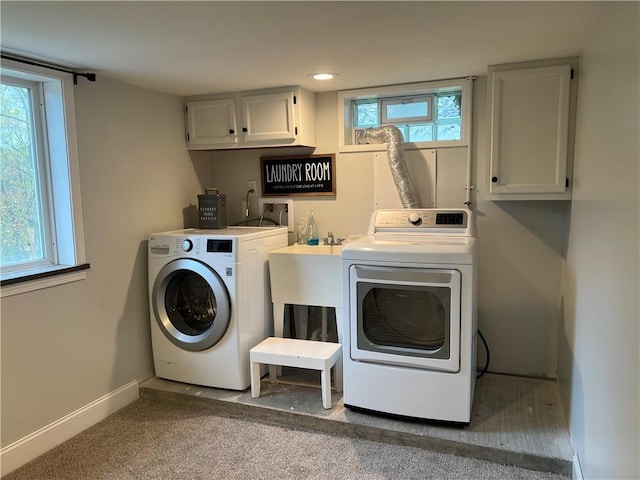 laundry room with cabinet space, a healthy amount of sunlight, washer and clothes dryer, and carpet floors