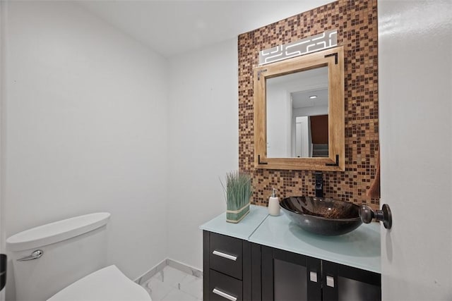 307 S Dithridge Unit 208, Oakland, PA 15213 - bathroom with marble look tiles, baseboards, toilet, vanity, and tasteful backsplash