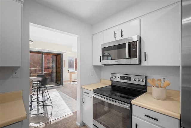 307 S Dithridge Unit 208, Oakland, PA 15213 - kitchen with appliances with stainless steel finishes, light colored carpet, light countertops, and white cabinetry