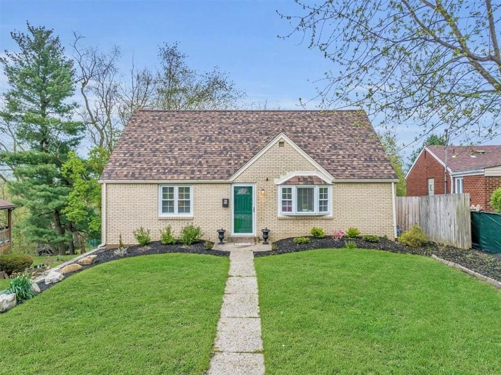 240 Crescent Pines Dr, Penn Hills, PA 15147 - view of front of home with brick siding, a shingled roof, a front lawn, and fence