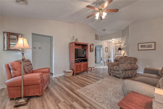 living room with baseboards, light wood-style flooring, ceiling fan, and vaulted ceiling