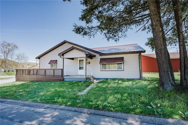 view of front of house featuring metal roof and a front yard