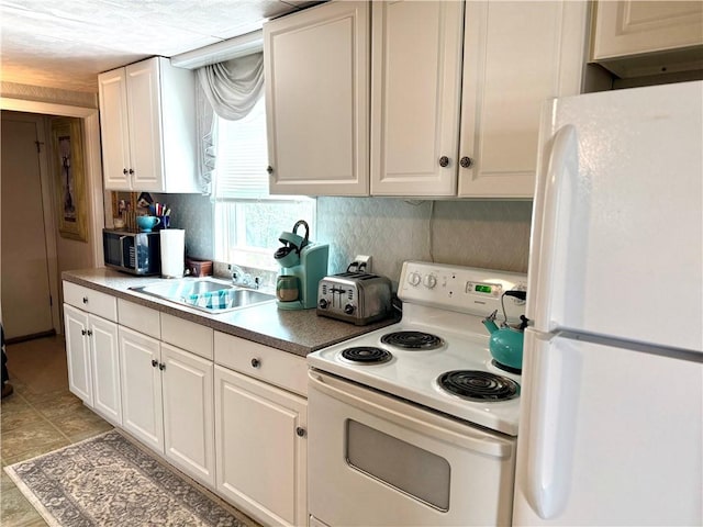 kitchen featuring a toaster, white appliances, white cabinets, a sink, and backsplash