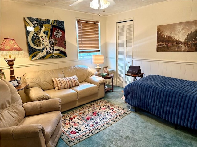 carpeted bedroom featuring wainscoting and a closet
