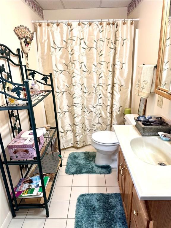 full bath featuring tile patterned flooring, curtained shower, toilet, and vanity