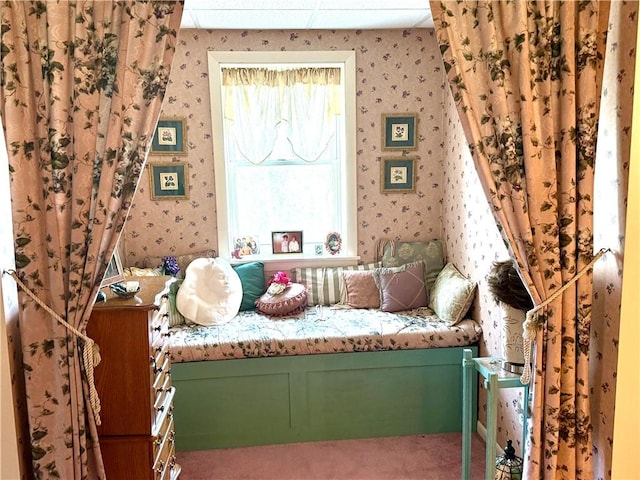 bedroom featuring carpet flooring, wallpapered walls, and a paneled ceiling