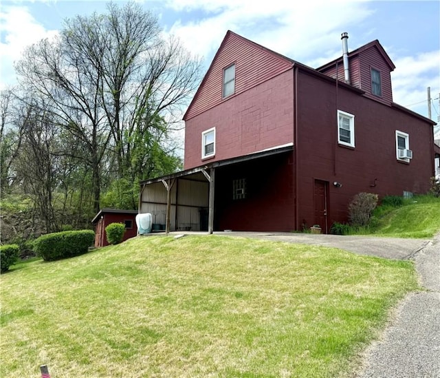 exterior space featuring a lawn, a carport, and aphalt driveway