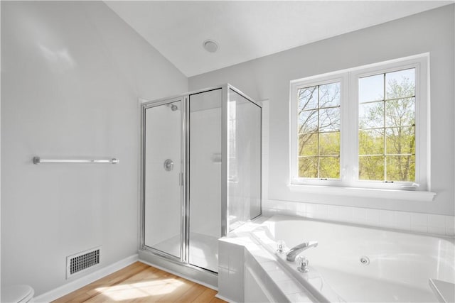 bathroom featuring visible vents, lofted ceiling, wood finished floors, a whirlpool tub, and a shower stall