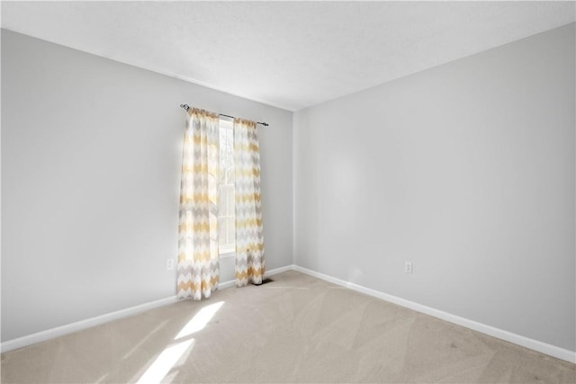 empty room featuring carpet floors and baseboards