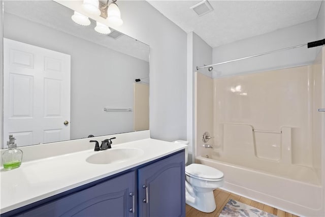 bathroom featuring visible vents, wood finished floors, vanity, toilet, and bathing tub / shower combination